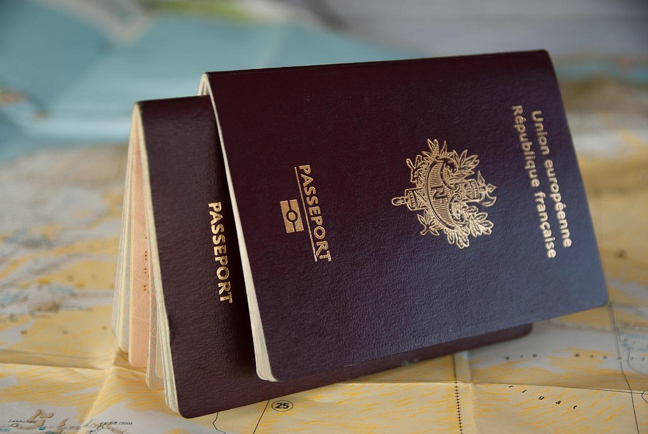 A passport open against a worn travel document, illustrating border crossings and the documents that govern migration.