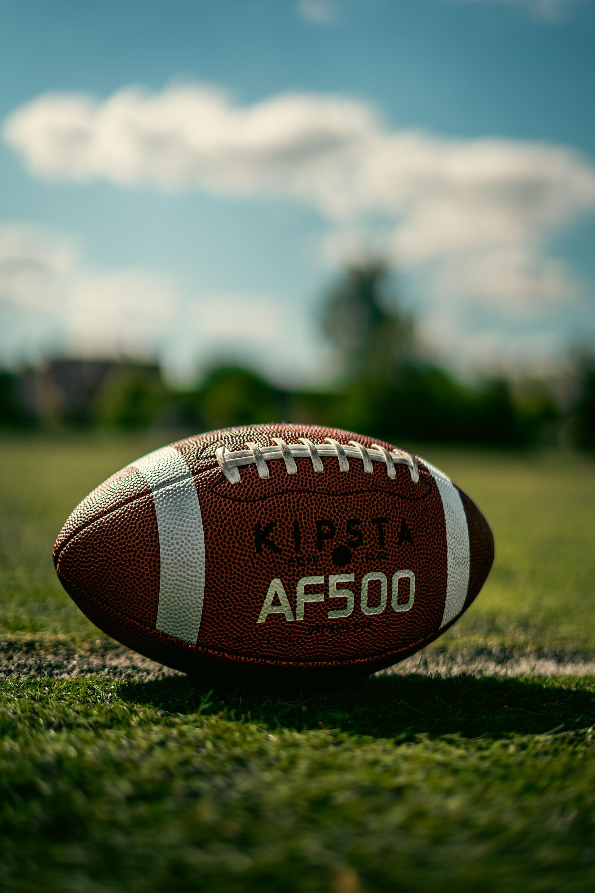 An oval rugby ball resting on a grassy field under a clear sky, a symbol of Kenya's rugby community