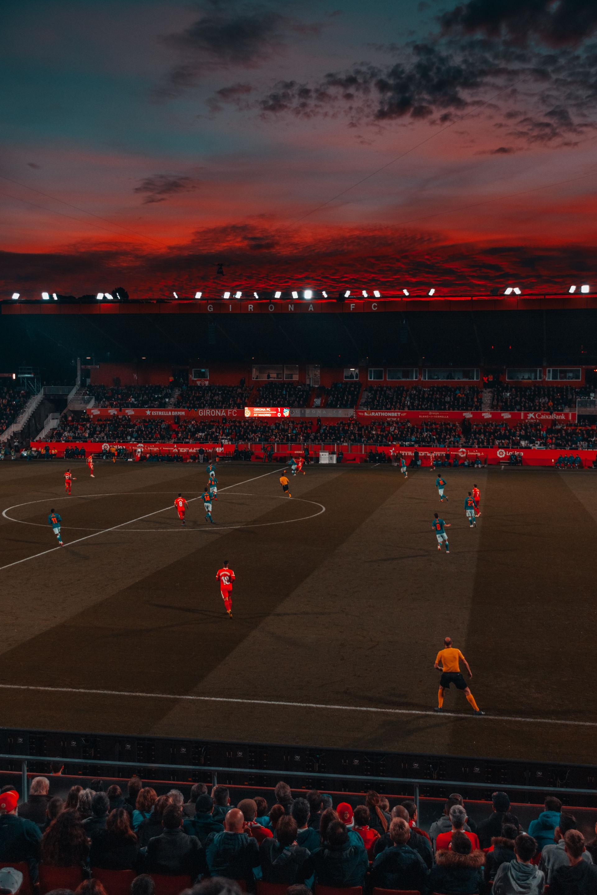 Footballers competing on a floodlit pitch, evoking the World Cup stage that draws African diaspora fans
