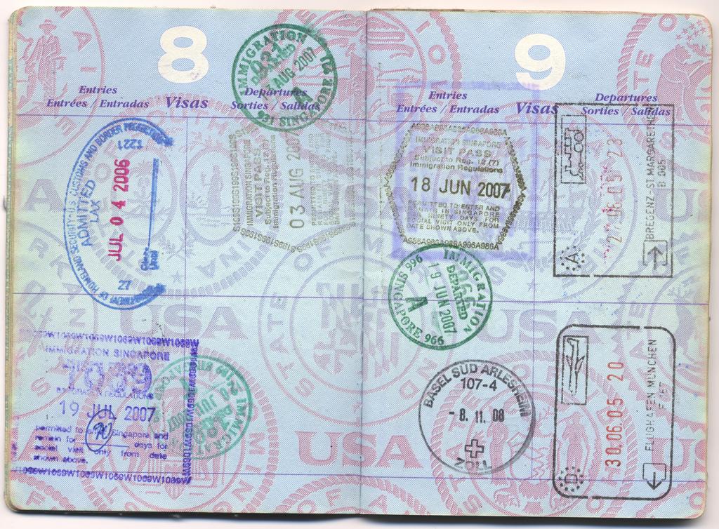 A United States passport open to pages filled with immigration and visa stamps.