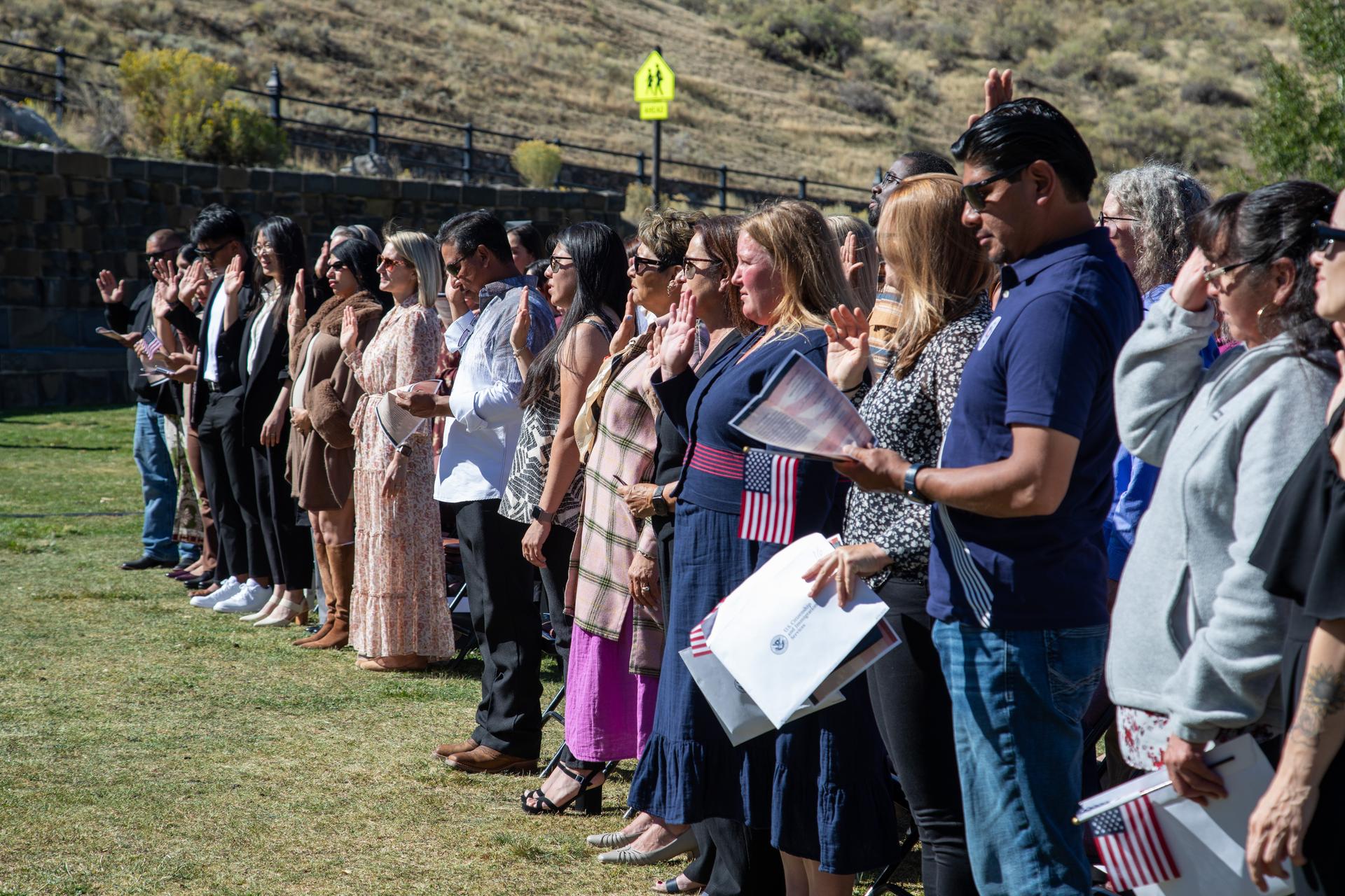 New citizens raise their right hands to take the Oath of Allegiance at a 2025 U.S. naturalization ceremony.
